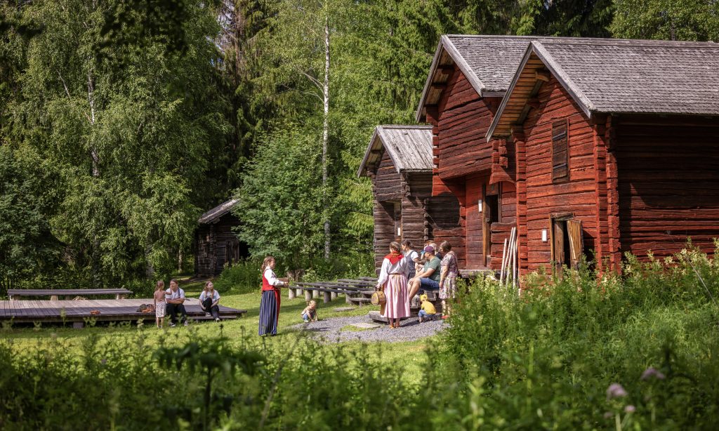 Staff and visitors of Turkansaari in front of historical granary buildings