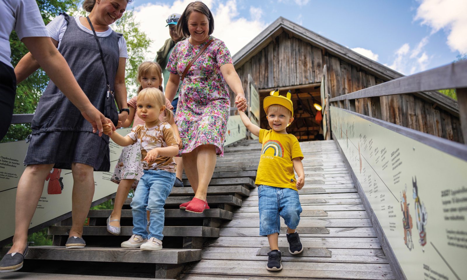 Children and adults walking down from the upper floor of an old building.