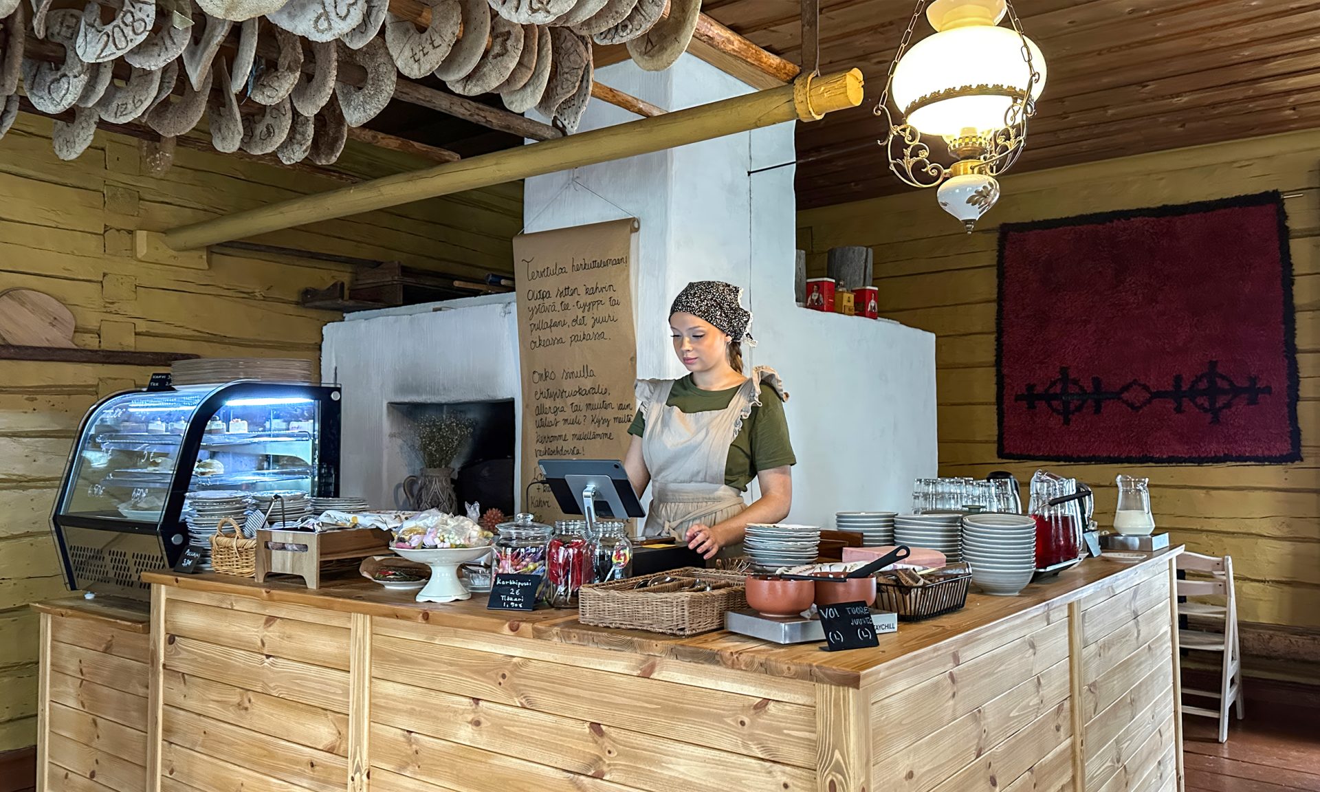 A cafe worker in traditional attire behind the cafe counter.